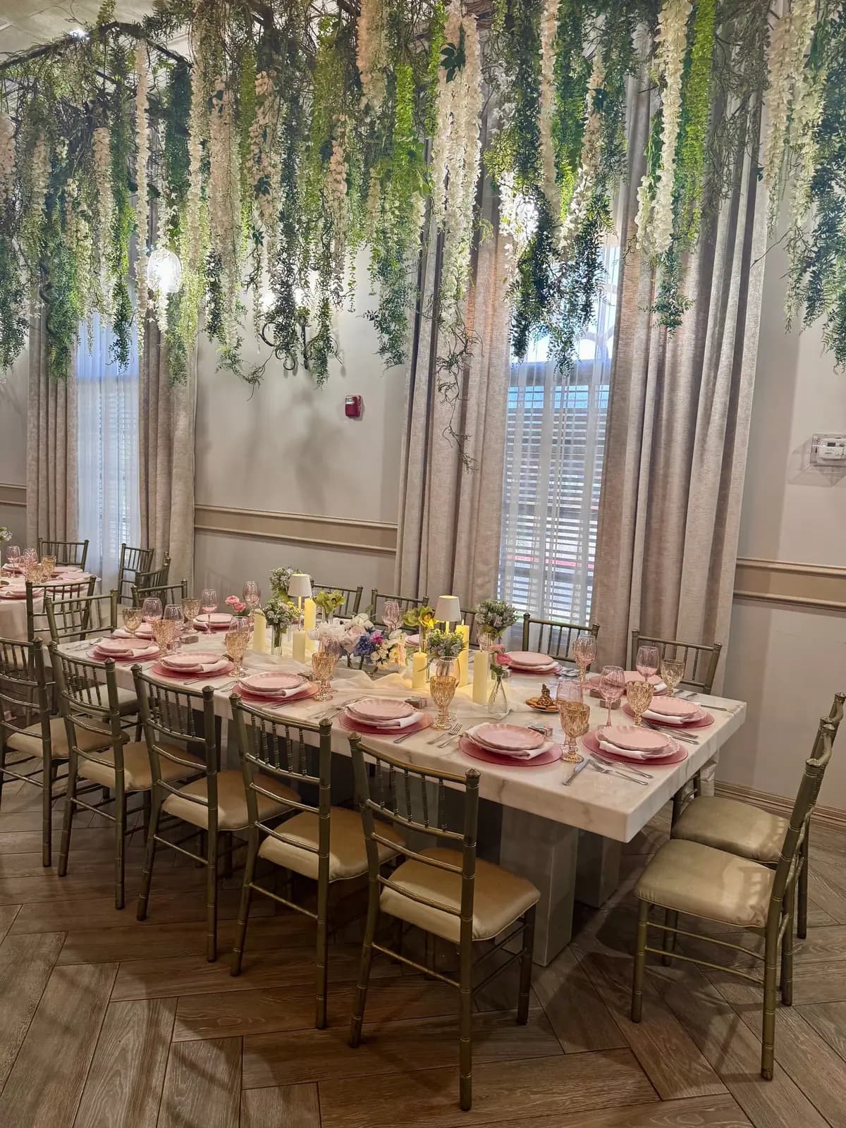 A table under hanging greenery, ready for guests
