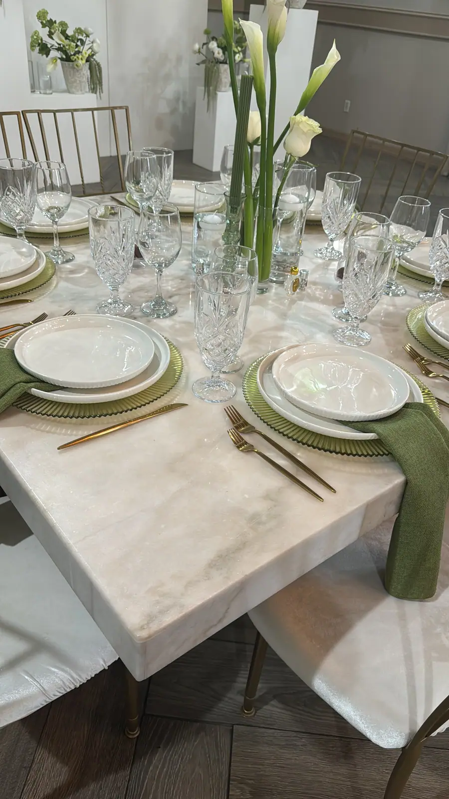 A white table with calla lilies and green napkins